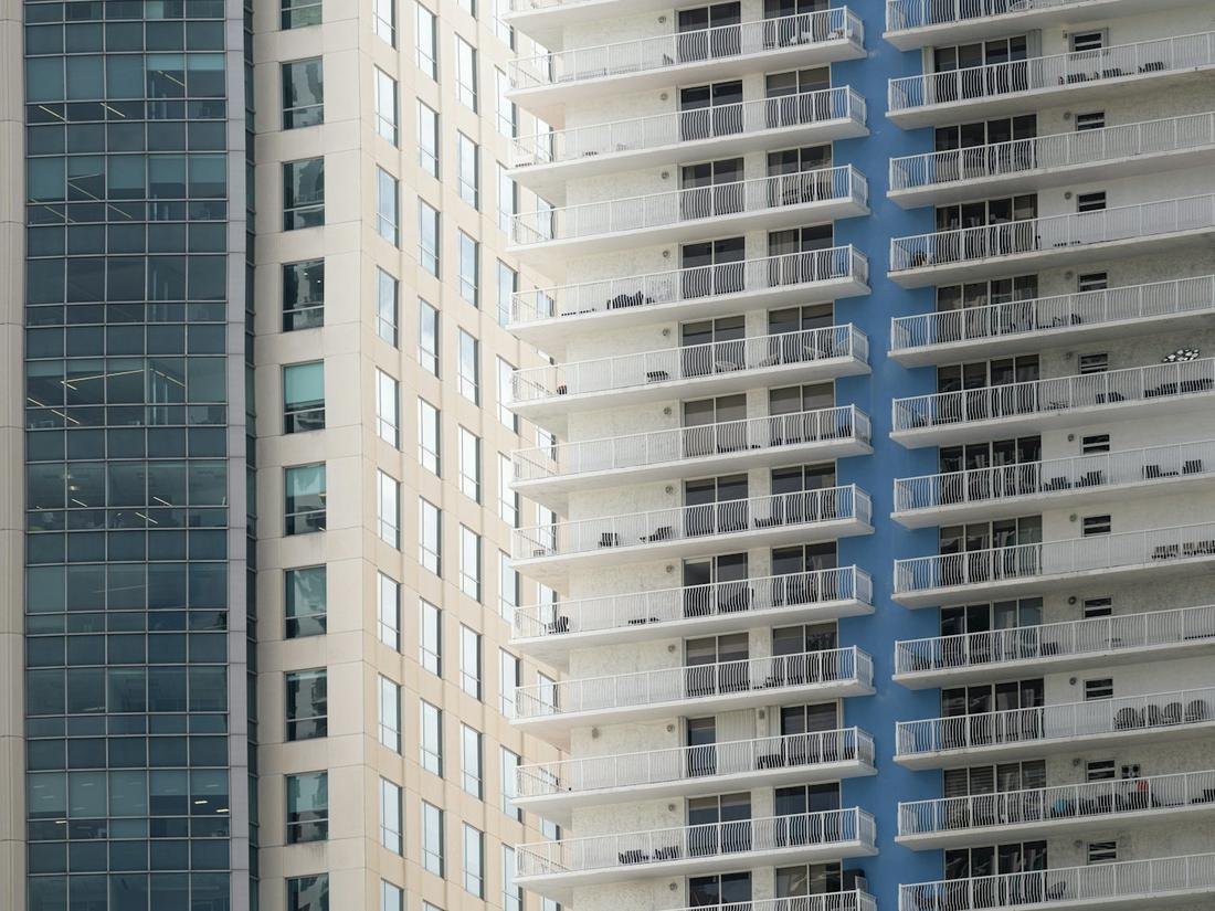 High-rise condo tower with rows of balconies and sliding glass doors