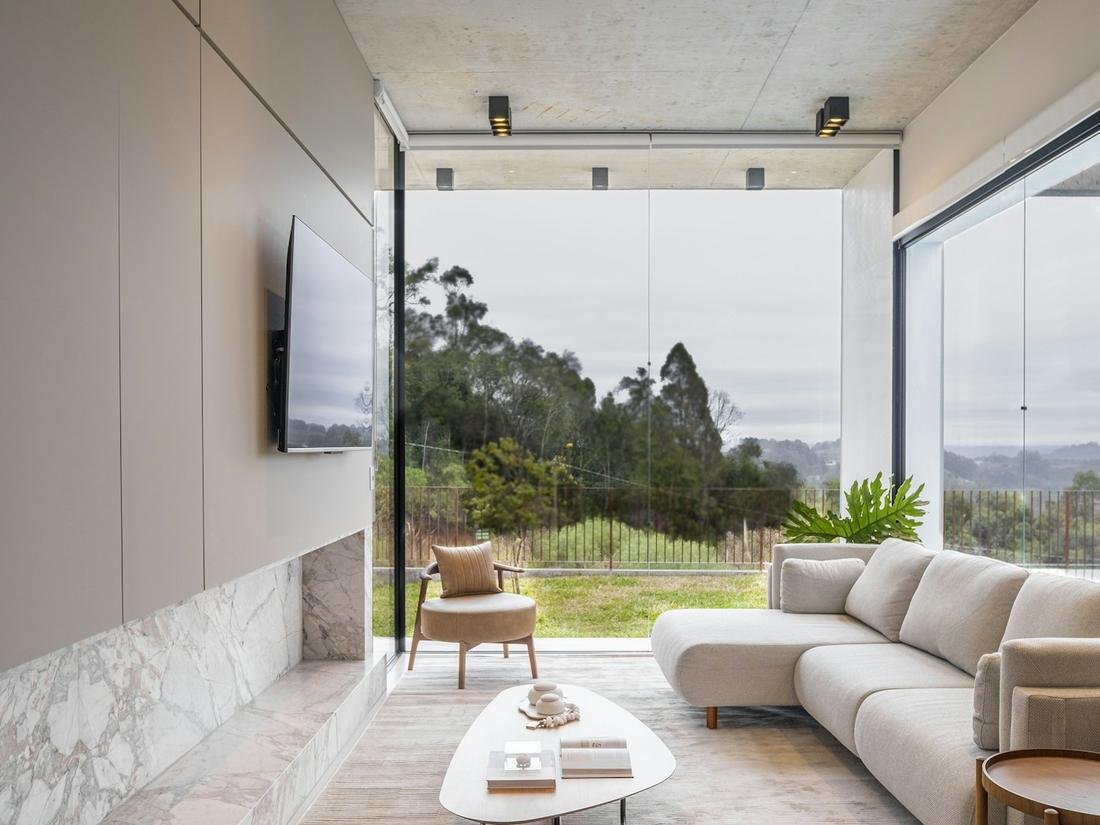 Bright living room with a wall of glass looking out to the trees